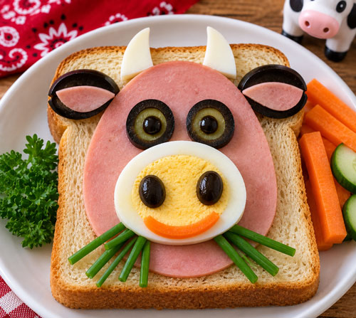 Cow face sandwich made with bologna egg olives and vegetables