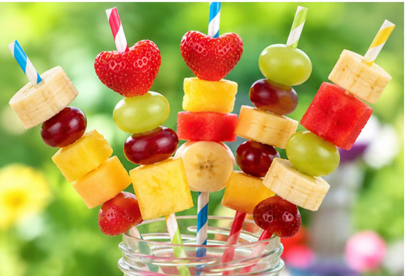 Colorful fruit pieces threaded onto a straw for a kids tea party