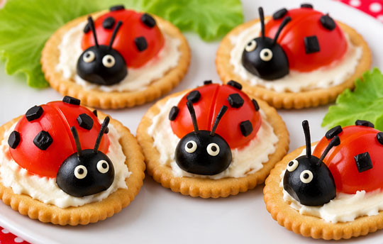 Ladybug crackers made with cherry tomatoes and olives