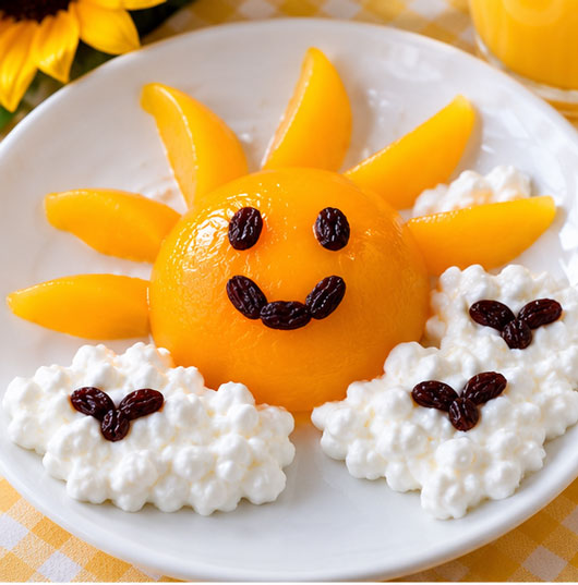 Peach half sunshine snack with cottage cheese and raisins