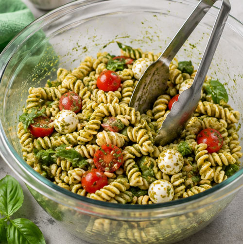 Pesto pasta salad with tomatoes Parmesan cheese and fresh basil
