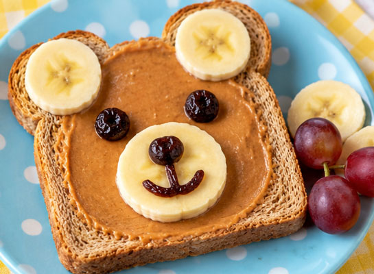 Teddy bear toast made with peanut butter, banana and fruit
