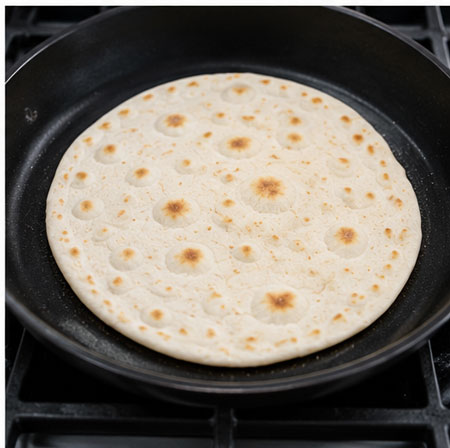 Cooking homemade flour tortillas on a skillet