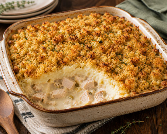 Thanksgiving leftovers casserole with turkey, mashed potatoes, cheese, and stuffing
