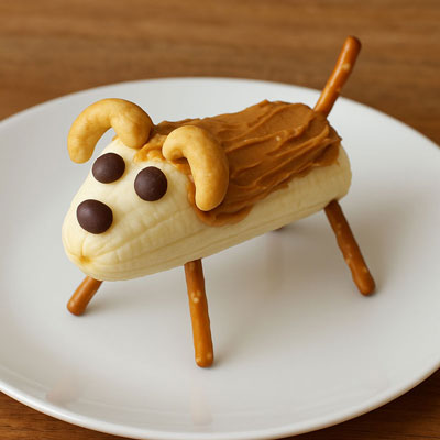 Banana dog snack made with a banana, pretzels, and candy decorations