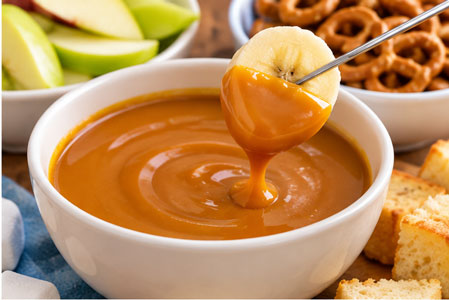 Warm butterscotch fondue with cake and fruit dippers