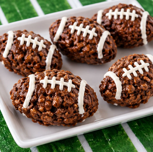 Chocolate crispy cereal treats shaped like footballs
