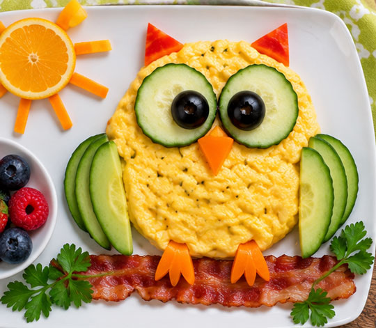 Owl omelet decorated with vegetables and bacon
