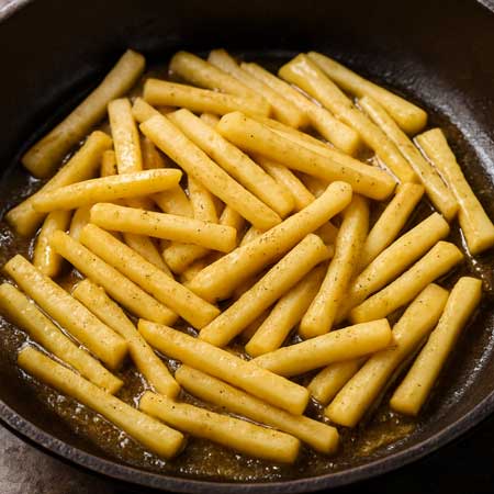 Nutmeg parsnip sticks in skillet