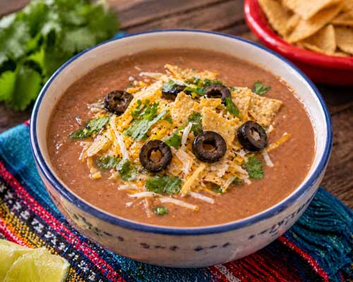 Mexican refried beans soup with toppings