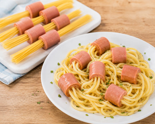 Spaghetti noodles cooked through pieces of hot dog