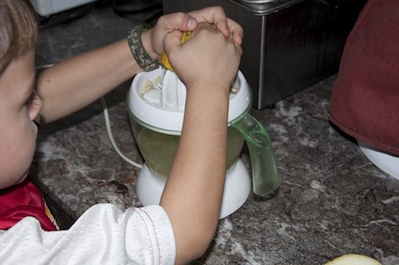 kids cooking lessons squeezes lemons to make lemonade