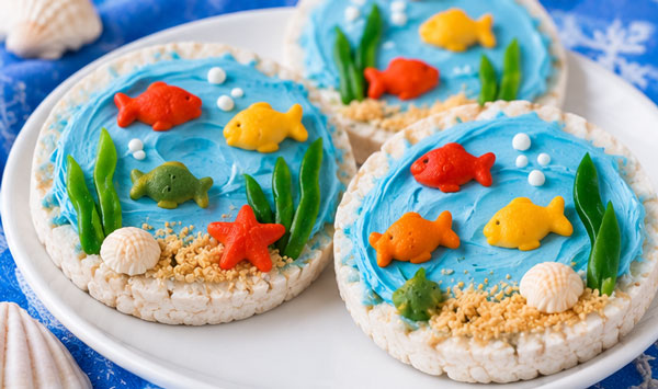 Rice cake decorated with blue topping and fish for an under the sea snack